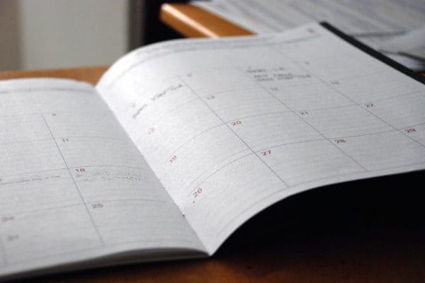 Open planner calendar on desk with handwritten notes