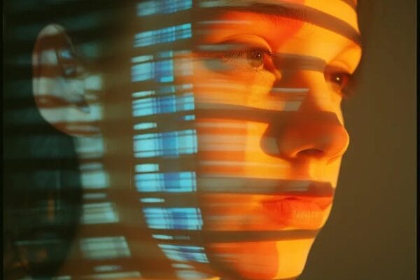 Human face with digital biometric scanning overlay patterns for liveness detection and deepfake analysis