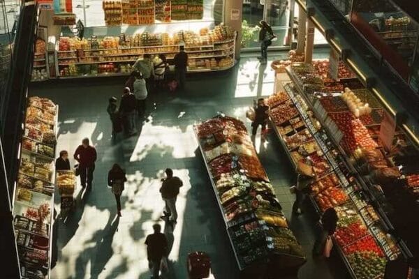 Overhead view of grocery store aisle with shoppers and stocked shelves