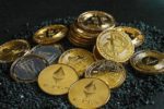 Pile of various cryptocurrency coins including Bitcoin and Ethereum, with distinctive metallic gold and silver colors and emblems, depicting the concept of digital decentralized currencies and blockchain technology.