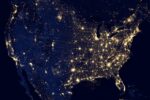 Night satellite image of the contiguous United States showing densely populated urban areas illuminated by bright clusters of lights against a dark background, depicting the vast scale and distribution of human settlements and infrastructure across the country.